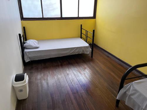 Habitación pequeña con cama y ventana en El Parque Bed and Breakfast, en Alajuela