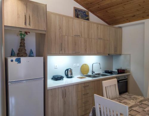 una cucina con frigorifero bianco e mobili in legno di Villa 29 a Sarandë