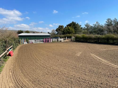 a dirt field with a barn in the background at The Stables in Newport