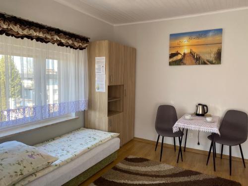 ウストロニエ・モルスキエにあるPokoje Gościnne Jolkaのベッドルーム1室(ベッド1台、テーブル、窓付)