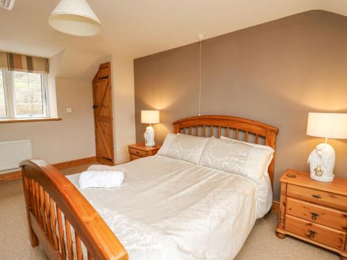 a bedroom with a large bed and two night stands at Cefn Cottage in Llangurig