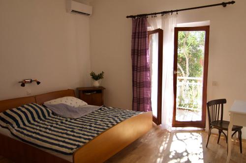 sypialnia z łóżkiem i przesuwnymi szklanymi drzwiami w obiekcie Villa Barbat 28 w mieście Barbat na Rabu