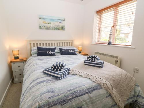 a bedroom with a bed with two pillows on it at Lilyvale in Camelford