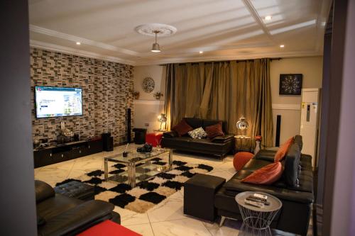 a living room with couches and a flat screen tv at Brynx Haven - Adenta, Accra in Accra