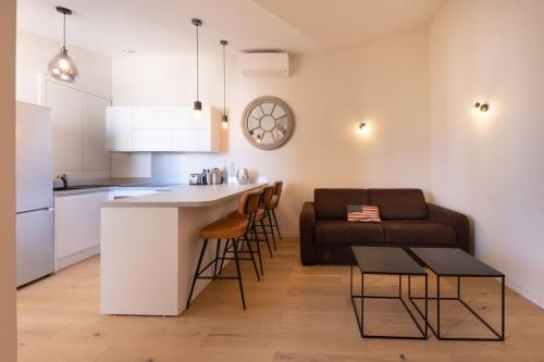 une cuisine et un salon avec un canapé et une table dans l'établissement 06AG - Bel appartement proche Palais des Festivals, à Cannes