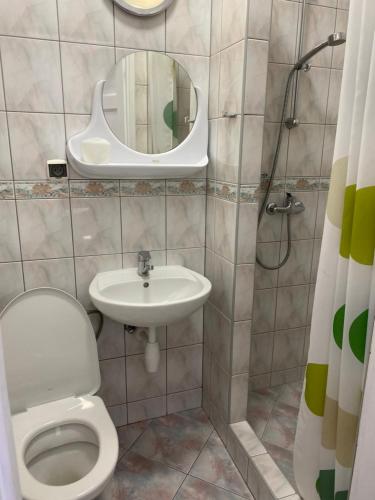 a bathroom with a toilet and a sink and a mirror at Pokoje Gościnne Jolka in Ustronie Morskie
