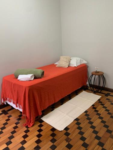 a bed with two pillows on it in a room at Quarto COMPÔ 6 in São João del Rei
