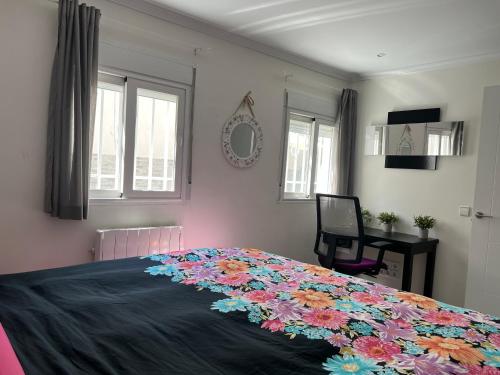 Un dormitorio con una cama con una manta de flores. en Luminoso apartamento con precioso y amplio patio, en Carabanchel Alto