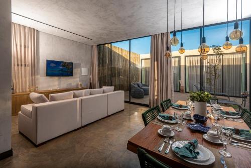 Uhane Luxury Villas في ساو ميجيل دو غوستوسو: غرفة طعام مع أريكة وطاولة