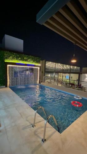 a pool at night with a frisbee in the water at PRIMOTEL Elite As Salamah - Serviced Apartments in Jeddah