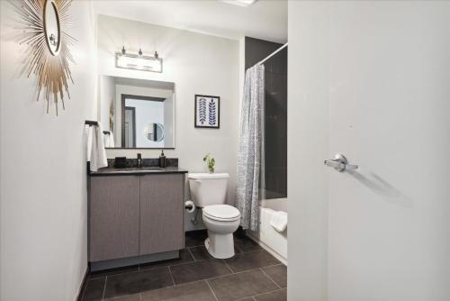 een badkamer met een toilet, een wastafel en een spiegel bij The Civic in Fairmount With Free Parking, Gym, Game Room in Philadelphia