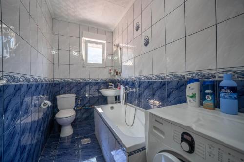 a blue tiled bathroom with a toilet and a sink at The view of Kotor - Sea & Old town view in Kotor