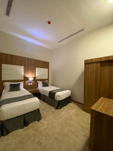 una habitación de hotel con 2 camas en una habitación en New Day Resort منتجع يوم جديد, en Taif