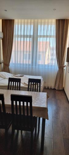 a room with a table and chairs and a bed at Elite Pension in Štúrovo