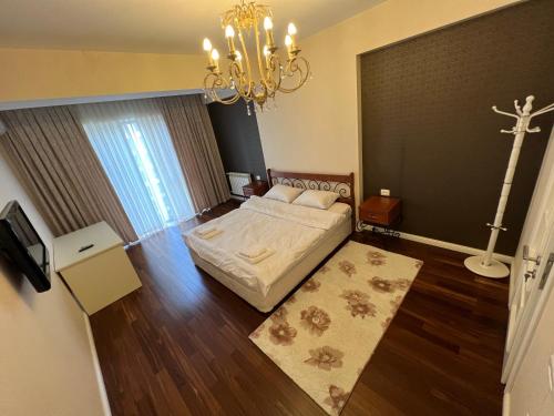 a bedroom with a bed and a chandelier at Park Azure 11054 in Baku