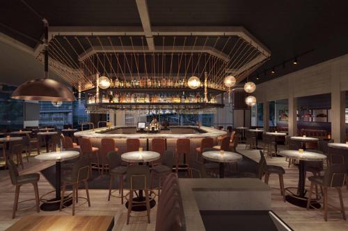 a restaurant with a bar with tables and chairs at JW Marriott Charlotte in Charlotte