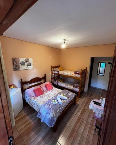 a small bedroom with two beds and a refrigerator at Pousada Valle das Aguas in Maria da Fé