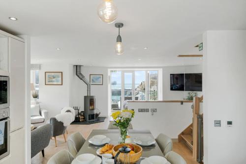 una cucina e un soggiorno con tavolo e sedie di Harbour Master's House a Portreath