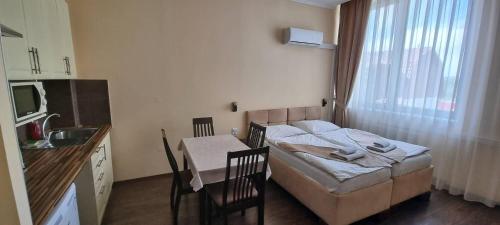 a small room with a bed and a kitchen with a sink at Elite Pension in Štúrovo