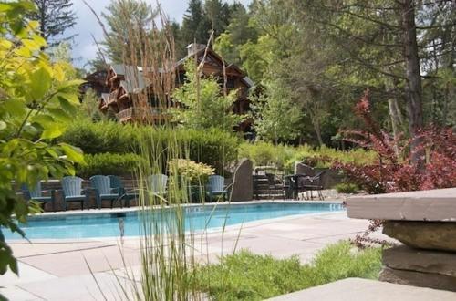 a swimming pool in a yard with chairs and trees at Seneca Lodge in Cooperstown