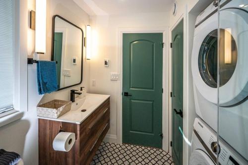 a bathroom with a green door and a sink at Stylish and Cozy Tiny House with King bed in Kitchener