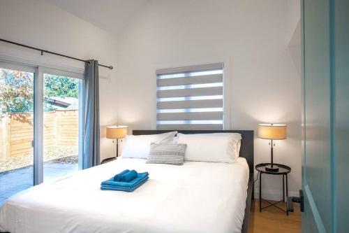 a bedroom with a white bed with two lamps at Stylish and Cozy Tiny House with King bed in Kitchener