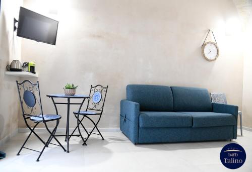 a living room with a blue couch and a table at B&B Talino in Trani