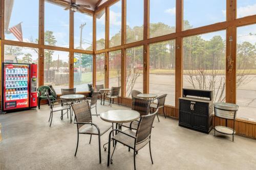 una habitación con mesas y sillas en un edificio con ventanas en The Lookout Lodge en Eureka Springs