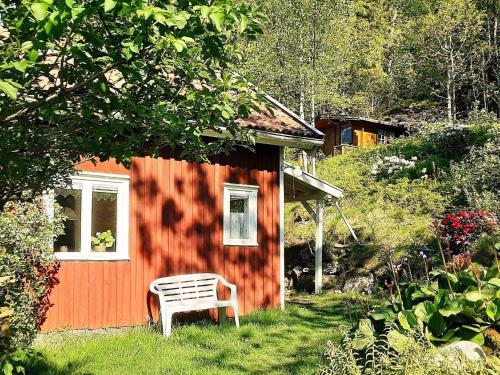 um banco sentado em frente a uma pequena casa em 6 person holiday home in HEN N em Henån