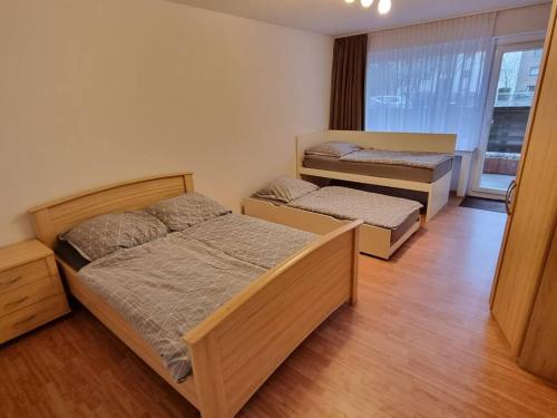 2 Betten in einem Zimmer mit Holzböden in der Unterkunft Viktoria's Wohnung in Kaarst in Kaarst