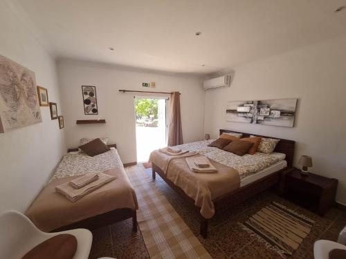聖巴托洛梅烏迪梅西尼什的住宿－B&B Quinta da Romãzeira，一间卧室设有两张床和窗户。