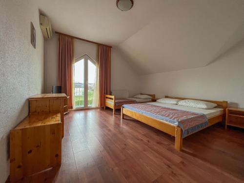 een slaapkamer met 2 bedden en een groot raam bij Hotel & Restaurant Babic in Vranovača