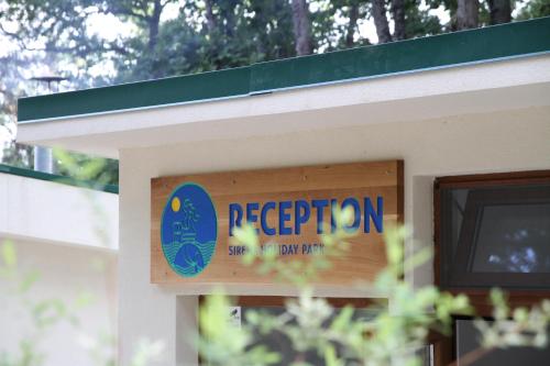 un letrero que lee recepción en un lado de un edificio en Sirena Holiday Park, en Kamchia