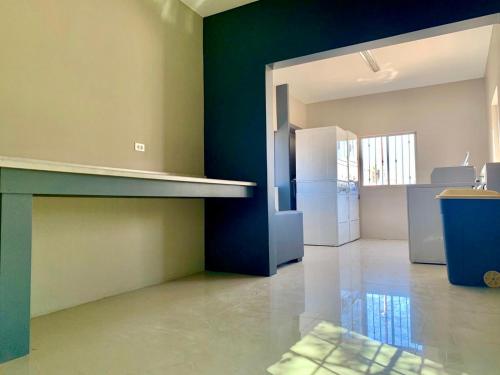 an empty kitchen with green walls and a refrigerator at soler 18 in Tijuana