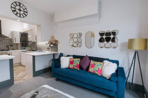 a living room with a blue couch and a kitchen at GROVE HOUSE NO.07 - Luxury Apartment close to the Llandudno Beach in Llandudno
