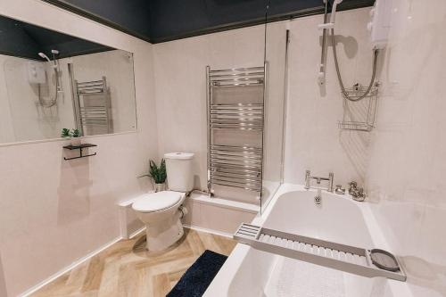 bagno bianco con vasca e servizi igienici di GROVE HOUSE NO.07 - Luxury Apartment close to the Llandudno Beach a Llandudno