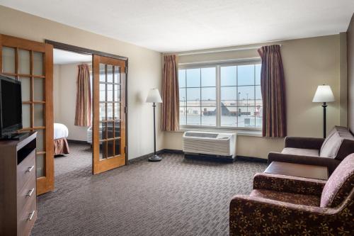 a hotel room with a living room with a couch and a television at AmericInn by Wyndham Cedar Rapids North in Cedar Rapids