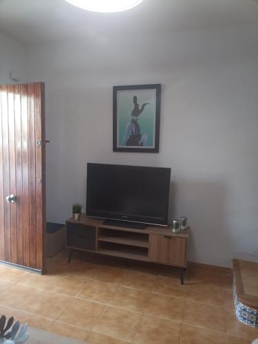 uma sala de estar com uma televisão de ecrã plano sobre uma mesa em Bungalow Gran Alacant em Gran Alacant
