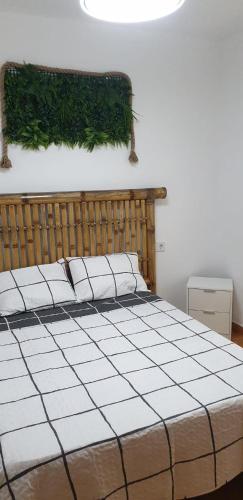 um quarto com uma cama grande com plantas verdes na parede em Bungalow Gran Alacant em Gran Alacant