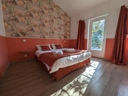 een slaapkamer met een bed met rode muren en een raam bij Gîte Petit Luberon chez Manon en Luberon in Lagnes