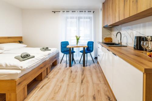 a bedroom with a bed and a table and chairs at Apartamenty Pod Wyciągiem in Wisła