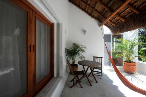 a balcony with a table and chairs on a house at Hotel Rancho Encantado in Bacalar