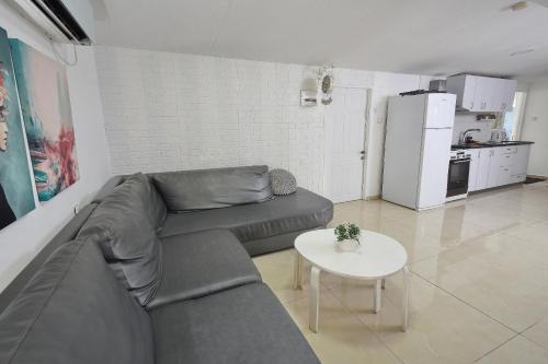 a living room with a couch and a table at מיקאסה ג'וי - וילה וסוויטה מדהימות עם בריכה פרטית in Wadi Keren
