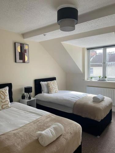 a bedroom with two beds and a window at Swindon City Center 2bed apartment with Parking and WiFi in Swindon
