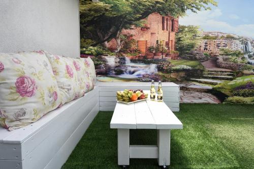a white bench with a table with a bowl of fruit at מיקאסה ג'וי - וילה וסוויטה מדהימות עם בריכה פרטית in Wadi Keren