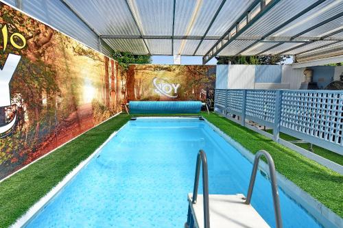 a large swimming pool with grass on the side of a building at מיקאסה ג'וי - וילה וסוויטה מדהימות עם בריכה פרטית in Wadi Keren