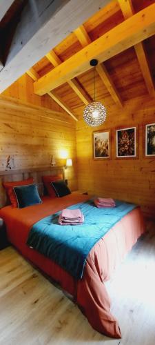 ein Schlafzimmer mit einem großen Bett in einem Holzzimmer in der Unterkunft Chalet l'Appel de la Forêt in Gérardmer