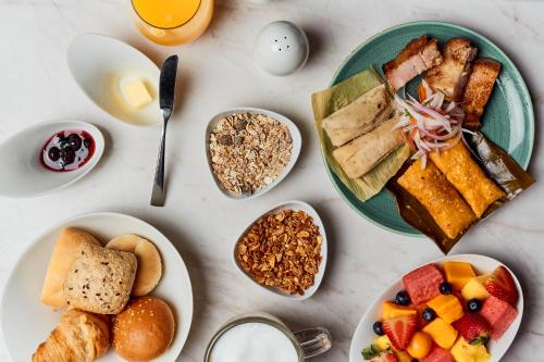 a table topped with plates of food and bowls of breakfast foods at Manto Hotel Lima - MGallery Collection in Lima