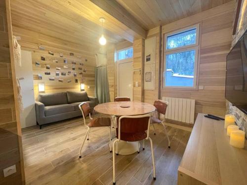 ein kleines Wohnzimmer mit einem Tisch und einem Sofa in der Unterkunft LE NID in Cauterets