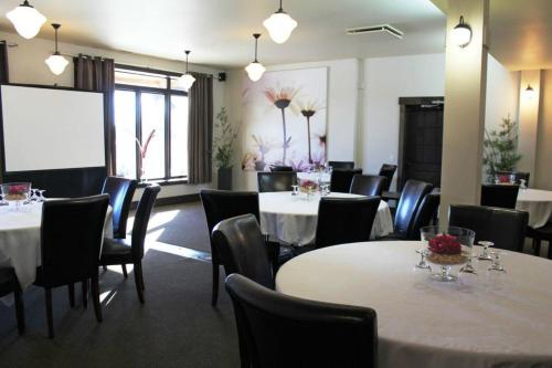 a conference room with tables and chairs and a projection screen at Espace 4 Saisons in Magog-Orford